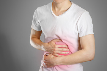 A man holds the stomach. The pain in his chest. Heartburn. Stomach hurts. Sore point highlighted in red. Closeup. Isolated