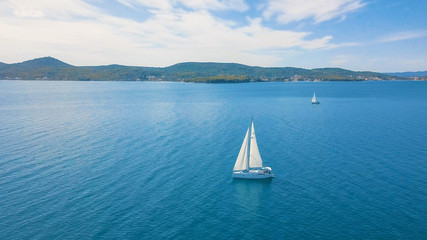 Aerial view of yacht sailing near beautiful Islands. Beautiful clouds in the background. Luxury yacht in the sea.