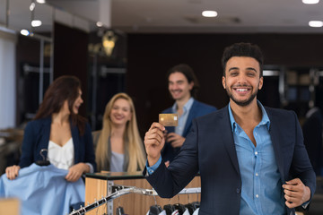 Wall Mural - Happy Smiling Man With Credit Card In Clothes Shop, Young Businessman Pay For Purchase