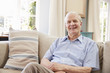 © Monkey Business - Portrait Of Smiling Senior Man Sitting On Sofa At Home