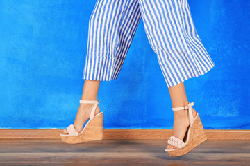 Wall Mural - Legs of beautiful young woman near color wall