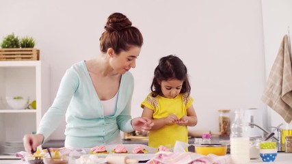 Wall Mural - mother and daughter cooking cupcakes at home