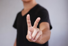 Young Man Showing Two Fingers Or Victory Gesture, Isolated Over White Background.