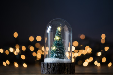 Wall Mural - Festive Christmas tree inside a glass snowglobe with blurred lights