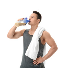 Wall Mural - Handsome young man drinking protein shake on white background