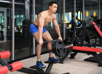 Wall Mural - Muscular man training in gym