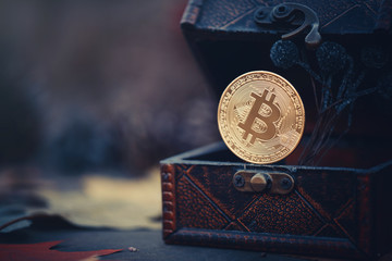 Golden bitcoin. Treasures - crypto currency mysterious. Old wooden box Virtual money on a dark background. warm toning