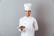© Drobot Dean - Happy young cook in uniform holding salad.