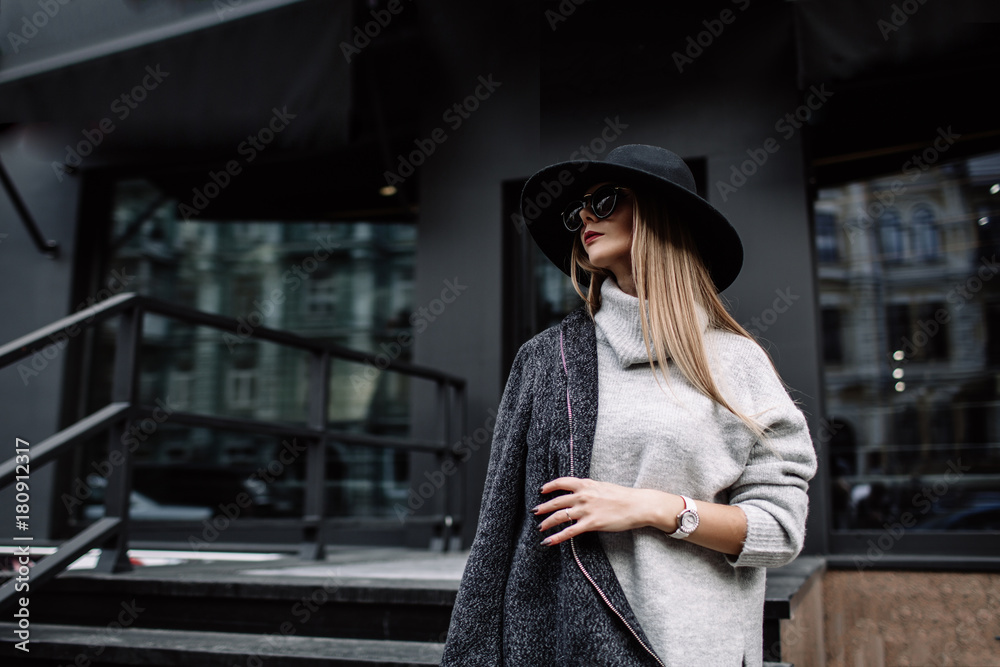 portrait of a young beautiful fashionable woman wearing sunglasses. A model in a stylish wide-brimmed hat. Harmoniously similar clothes in gray tones. Uleach style of shooting. Women's fashion. - obrazy, fototapety, plakaty 