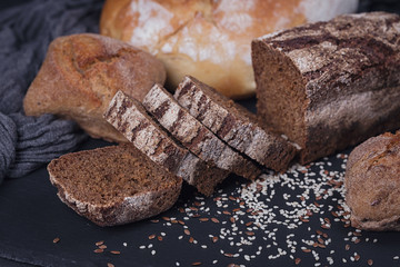 Wall Mural - Assortment of baked bread on dark background.