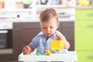 Poster - Adorable baby sitting in highchair at home