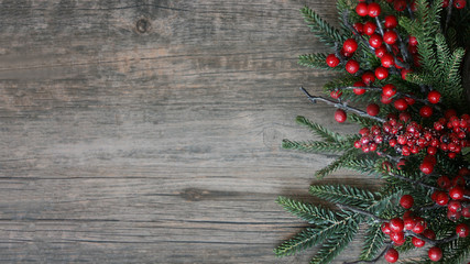 Wall Mural - christmas evergreen branches and berries over rustic wood horizontal background
