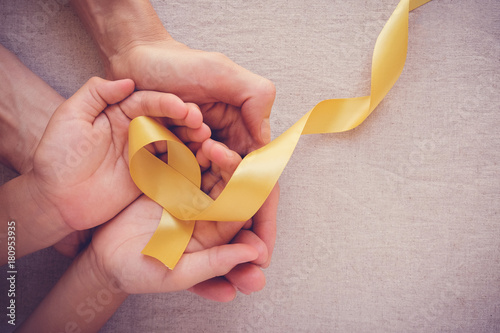 Fotomural adult and child hands holding yellow gold ribbon, Sarcoma Awareness, Bone cancer