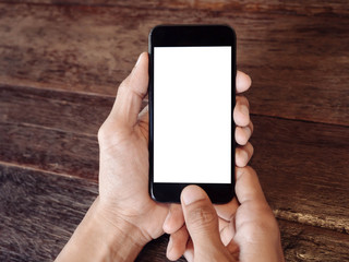Poster - Closeup of man's hand is holding a black cell phone with blank white screen that you can put any ideas in this space on wood table at coffee cafe 