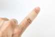 Adhesive bandage on index finger against white background