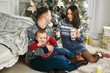 © fisher05 - Happy family in Christmas decor . Parents with a young son on Christmas day