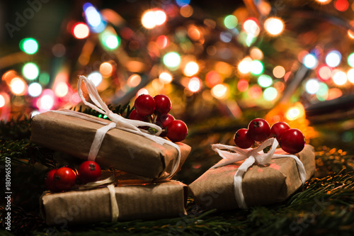 Fotografía Christmas gift in rustic style and colorful lights blurred in the background