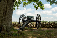 Historic Cannon Artillery Pointing Over Stone Wall