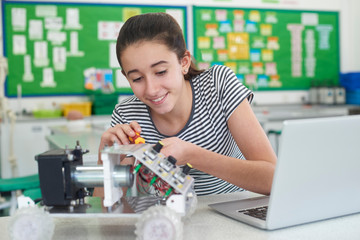 Wall Mural - female pupil in science lesson studying robotics