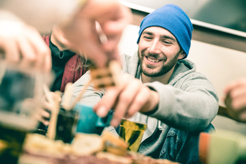 Happy guy with friends eating finger food and drinking beer at pub - Cheerful people having fun at brewery bar restaurant corner - Friendship concept on vintage desaturated filter with focus on face