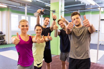 Wall Mural - group of happy friends in gym showing thumbs up