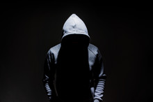 Silhouette Of Man In The Hood, Dark Mysterious Man Hoodie, Murderer, Hacker, Anonymus On The Black Background With Free Space