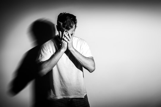 Fototapete - sad man with hands on face in sadness, on white background, black and white photo, free space