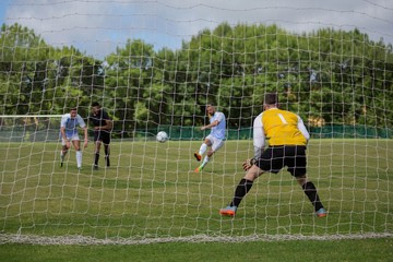 Wall Mural - Soccer player kicking ball towards goal post