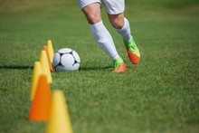 Soccer Player Dribbling Through Cones