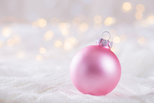 Pink Christmas Ball On White Lace On Light And Warm Bokeh Background