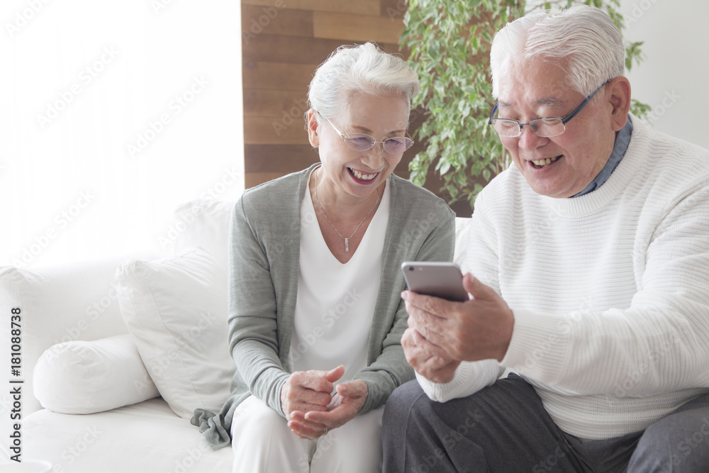 An old couple is using smartphones as they get along - obrazy, fototapety, plakaty 