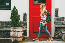 Young Woman With Backpack Walking In City Red Door House On Background Travel Lifestyle Concept Vacations