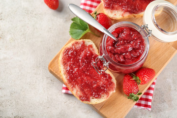 Wall Mural - Jar and piece of bread with strawberry jam on table