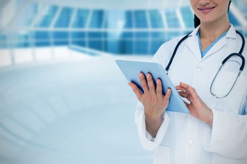 Poster - Composite image of happy doctor using her tablet pc