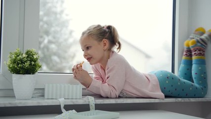 video. portrait of happy girl surprising her gifts at the window. it is snowing