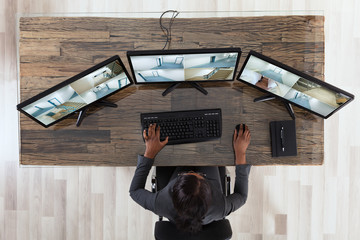 Poster - Businesswoman Looking At Multiple Camera Footage In Office