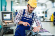 © NDABCREATIVITY - modern industrial machine operator working in factory