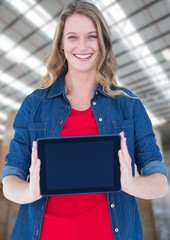 Canvas Print - Woman holding tablet with warehouse background