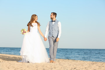 Wall Mural - Happy wedding couple on sea beach