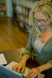 © PhotoAlto - Woman using a laptop while sitting at home