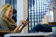 © PhotoAlto - Woman relaxing at home with smartphone