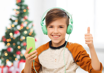 Canvas Print - boy with smartphone and headphones at christmas