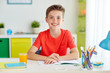 © Syda Productions - happy student boy writing to notebook at home