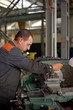 © andov - metalworking industry: factory man worker in uniform working on lathe machine in workshop