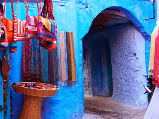 Sticker - the gorgeous blue alleyways and blue-washed building with the souvenirs in chefchaouen, morocco