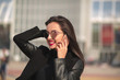 © vpavlyuk - Happy brunette woman talking on mobile telephone at the street in sunny day