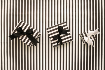 Top view. Black and white gift boxes on a  striped background