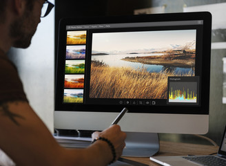 Fototapete - Man editing photos on a computer