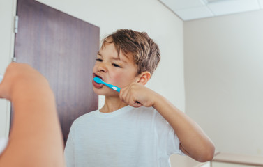 Wall Mural - Little  boy brushing teeth in bathroom