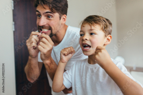 Fotomural Father and son cleaning teeth with dental floss
